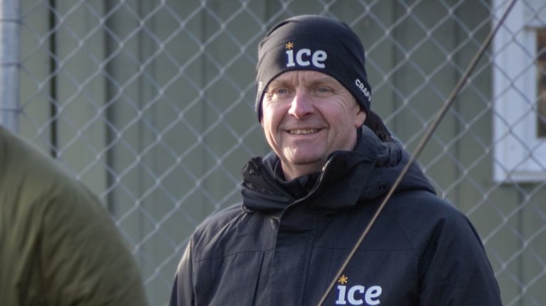 Smilende mann ikledd svart lue og svart jakke med Ice-logo