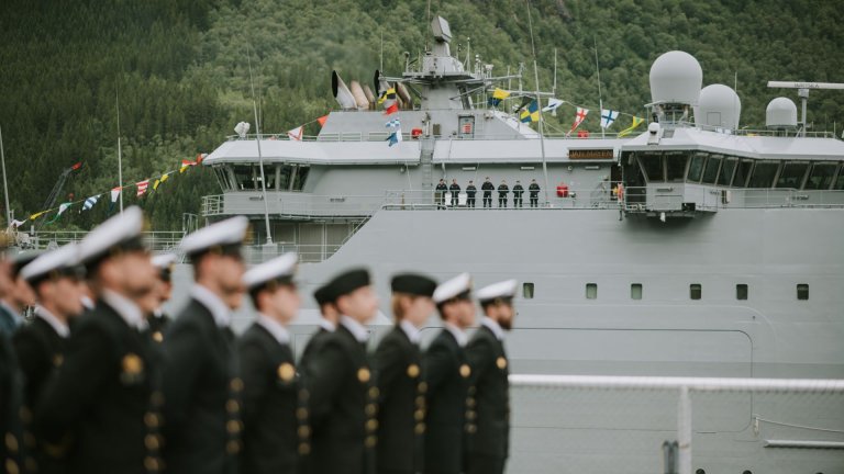 Uniformskledde soldater oppstilt foran et kystvaktskip